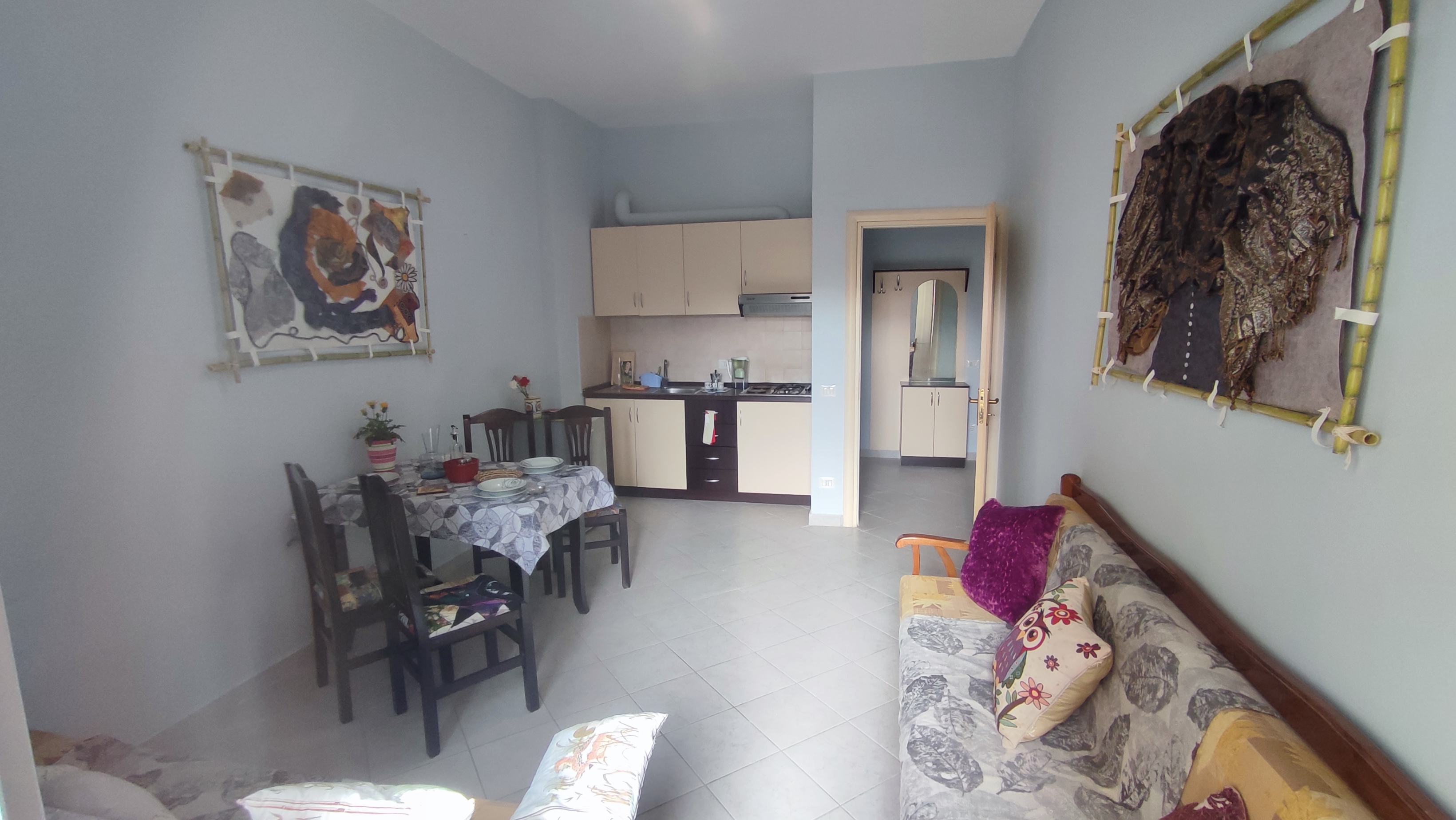 Centaury Apartment with a Sofa, the kitchen, a table and chairs.