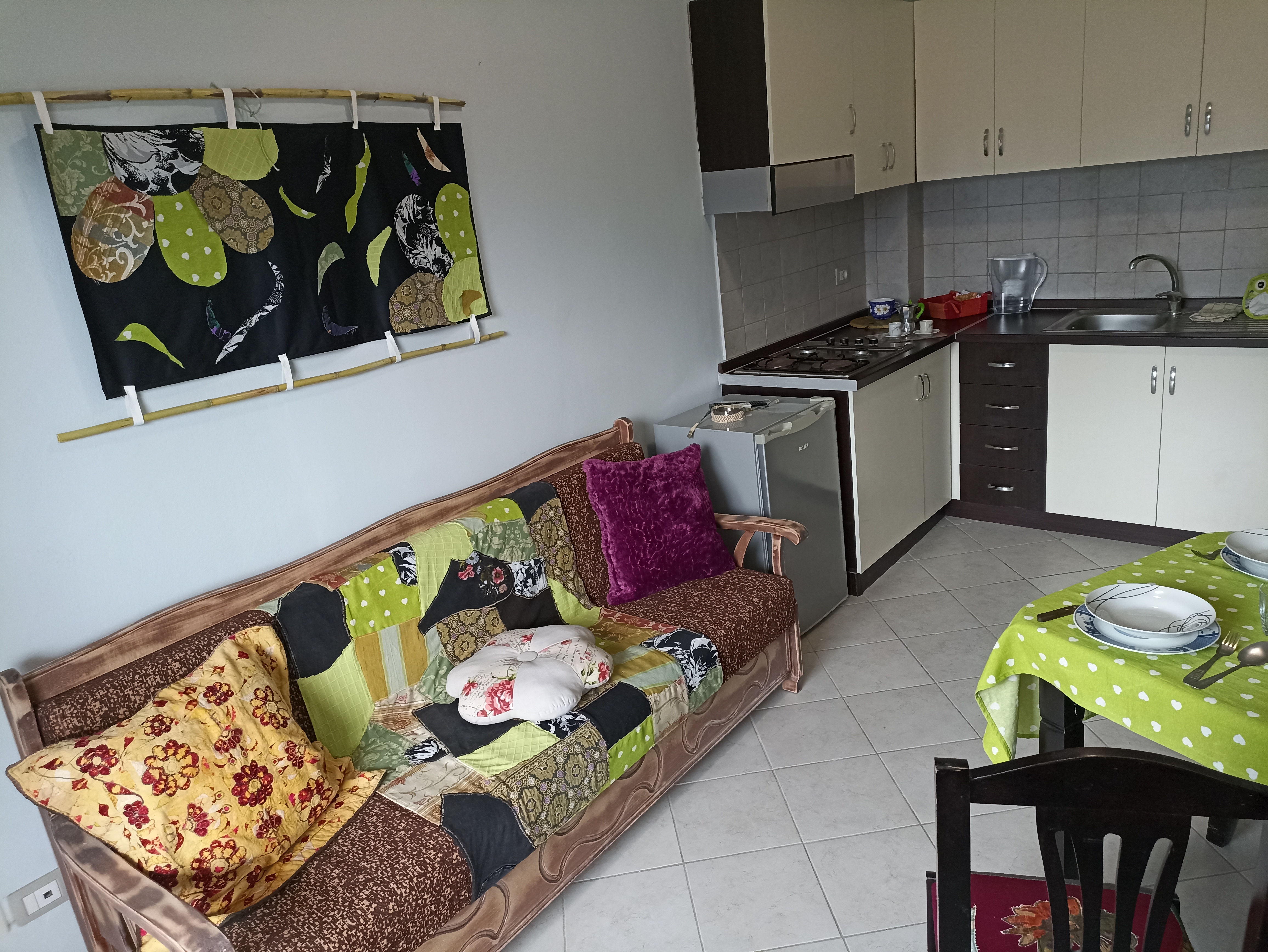 Apartment Walnut's living-room with sofa, kitchen, table and chairs.